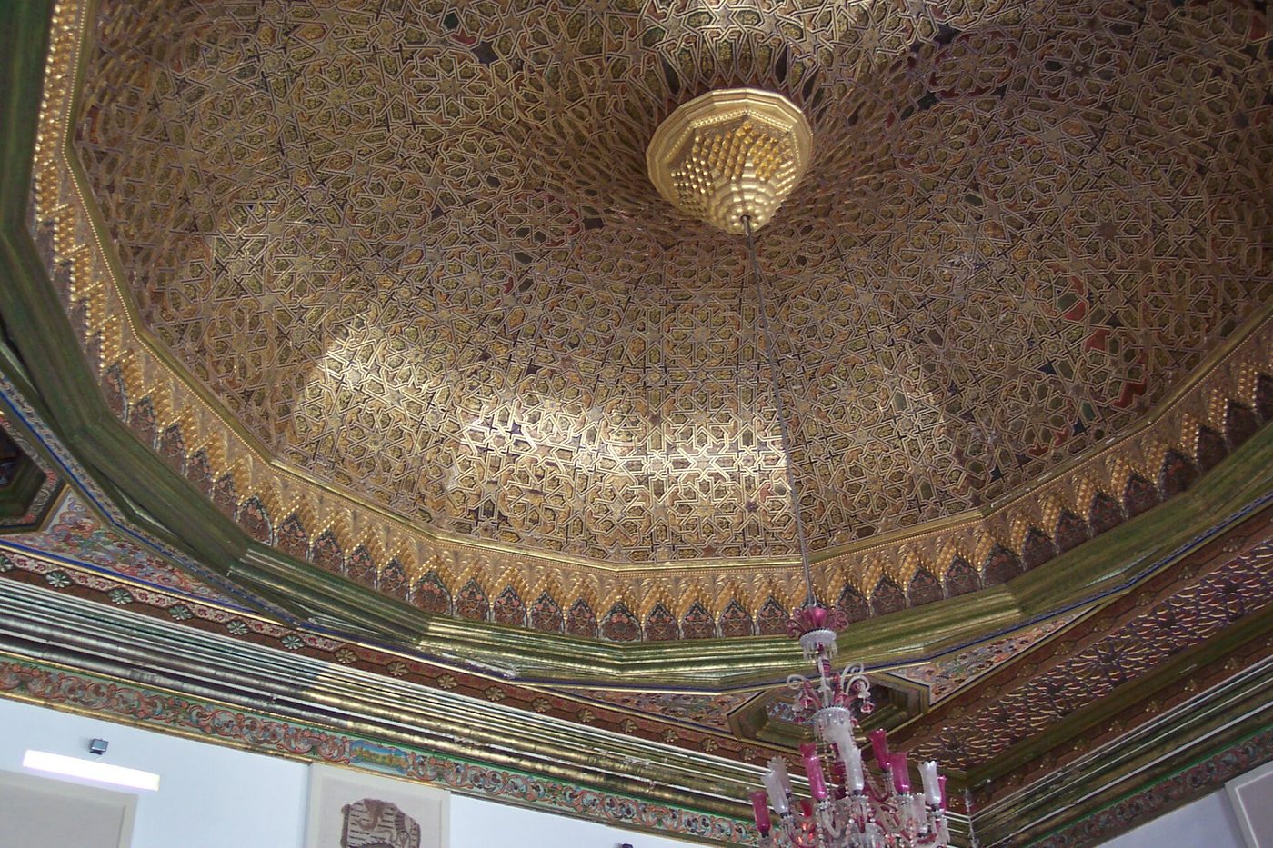 An ornate former beylical palace hall with carved ceiling housing mosaics inside the Bardo Museum