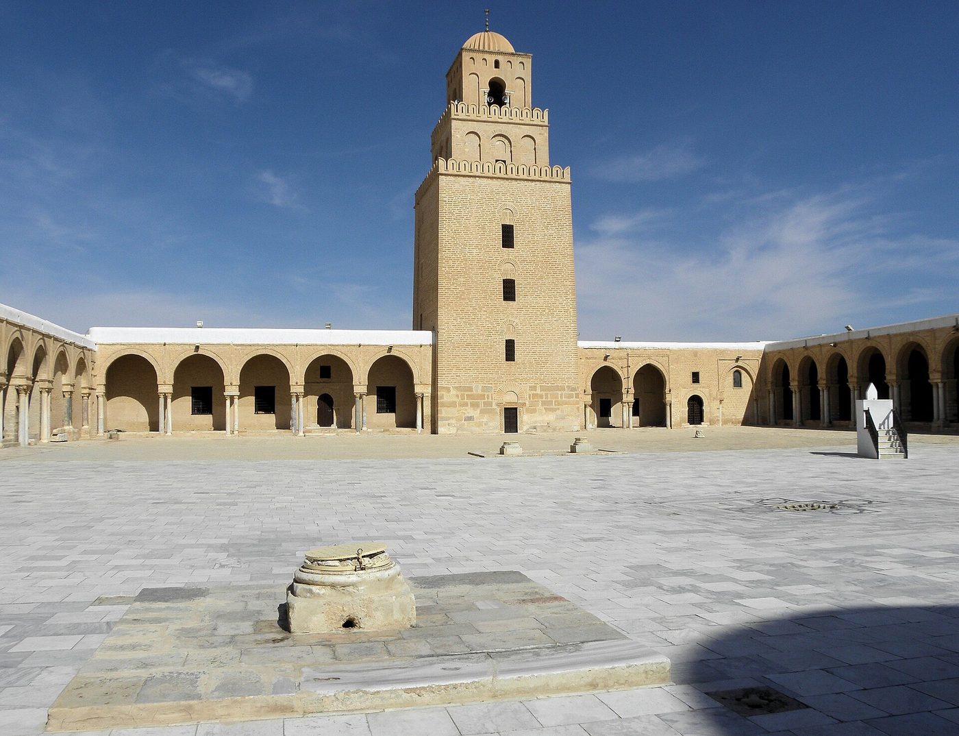 The sunlit courtyard and minaret of the Great Mosque of Kairouan, Tunisia.