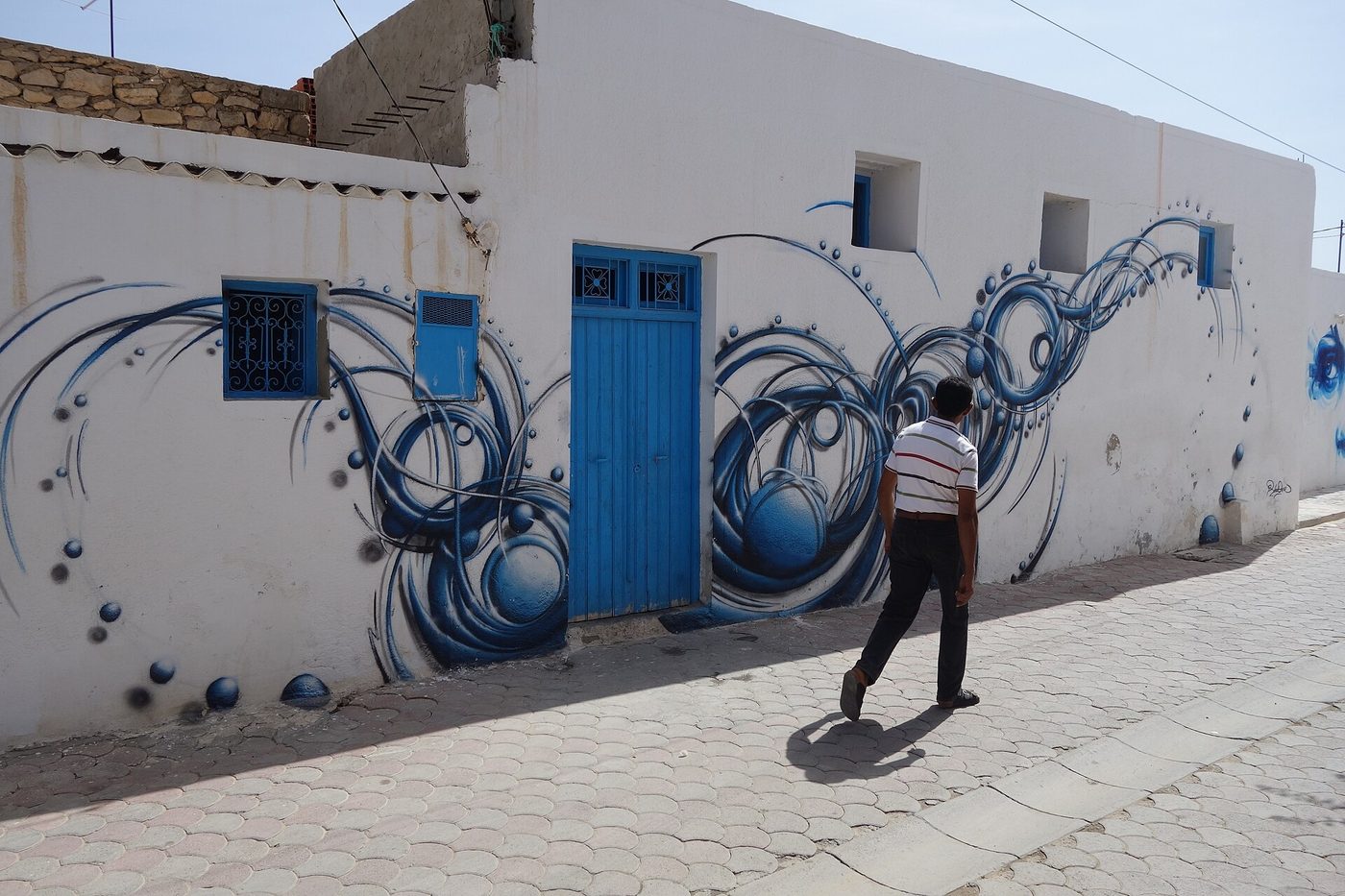 A bold full-wall mural by an international artist in the Djerbahood open-air museum, Erriadh, Djerba