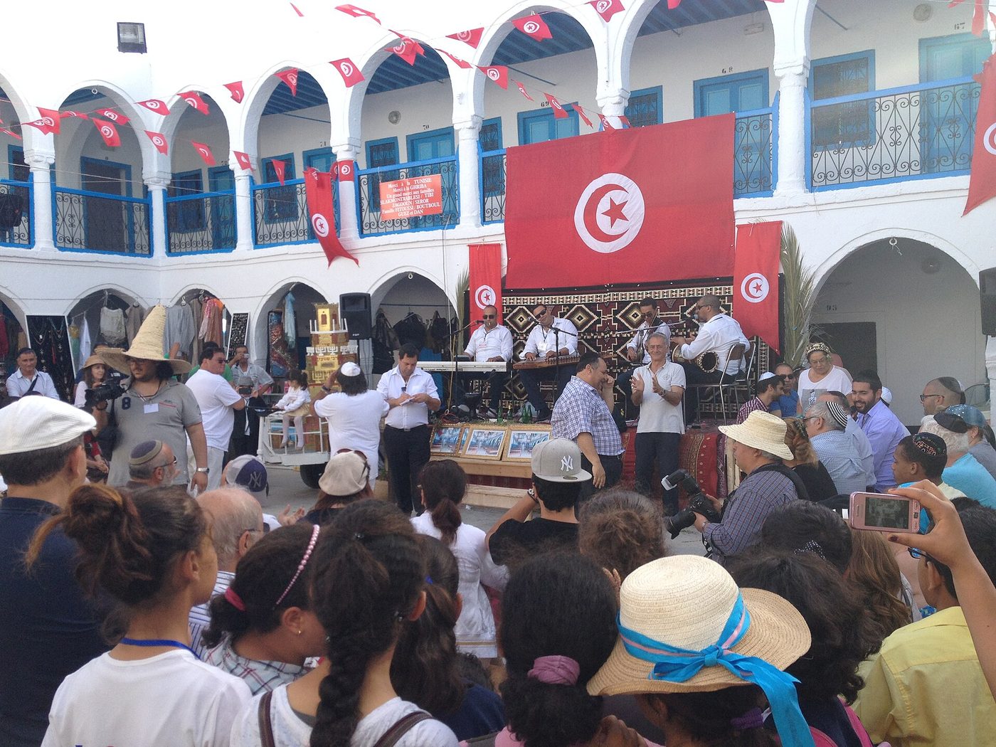Pilgrims and the decorated menara during the Lag BaOmer pilgrimage at El Ghriba, Djerba