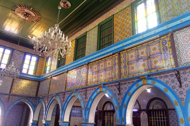 The blue-tiled interior arcades of the El Ghriba synagogue at Erriadh, Djerba
