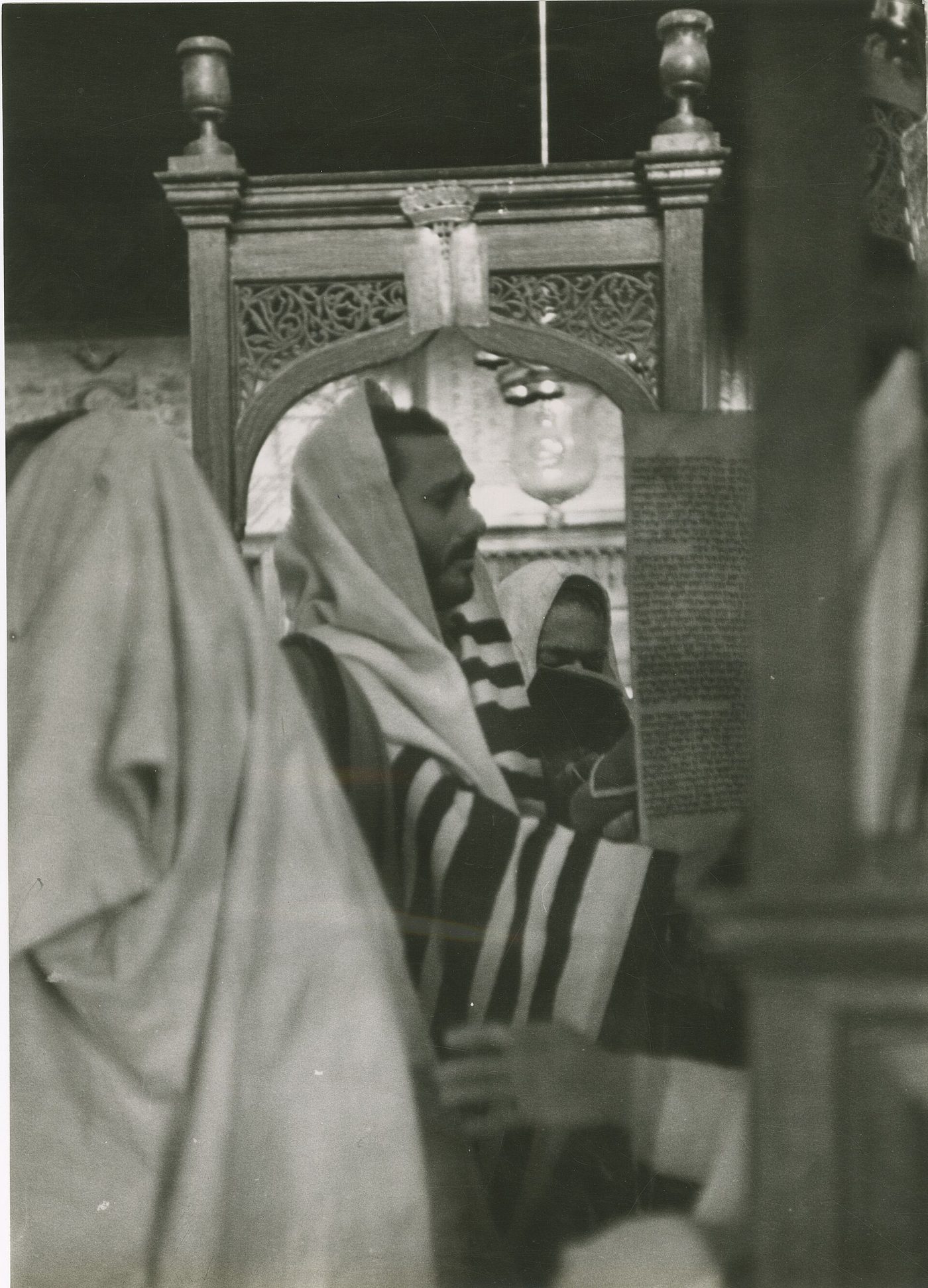 A rabbi reading from a Torah scroll inside the El Ghriba synagogue, Djerba (historic photograph, 1952)