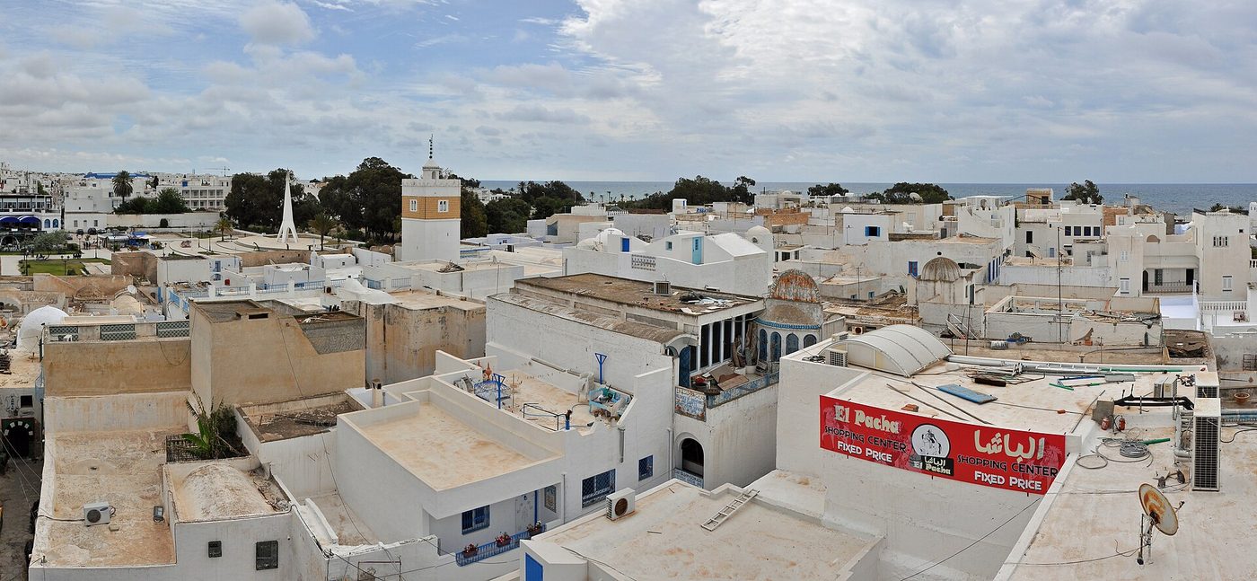 The whitewashed walls of Hammamet's 15th-century medina meeting the sea, with the kasbah on the headland