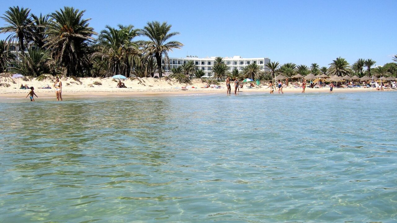 The busy summer beach and warm sea at Sousse, Tunisia in July