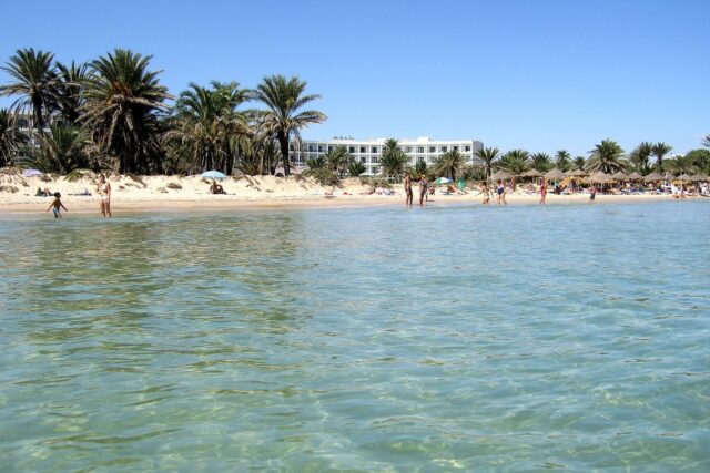 The busy summer beach and warm sea at Sousse, Tunisia in July