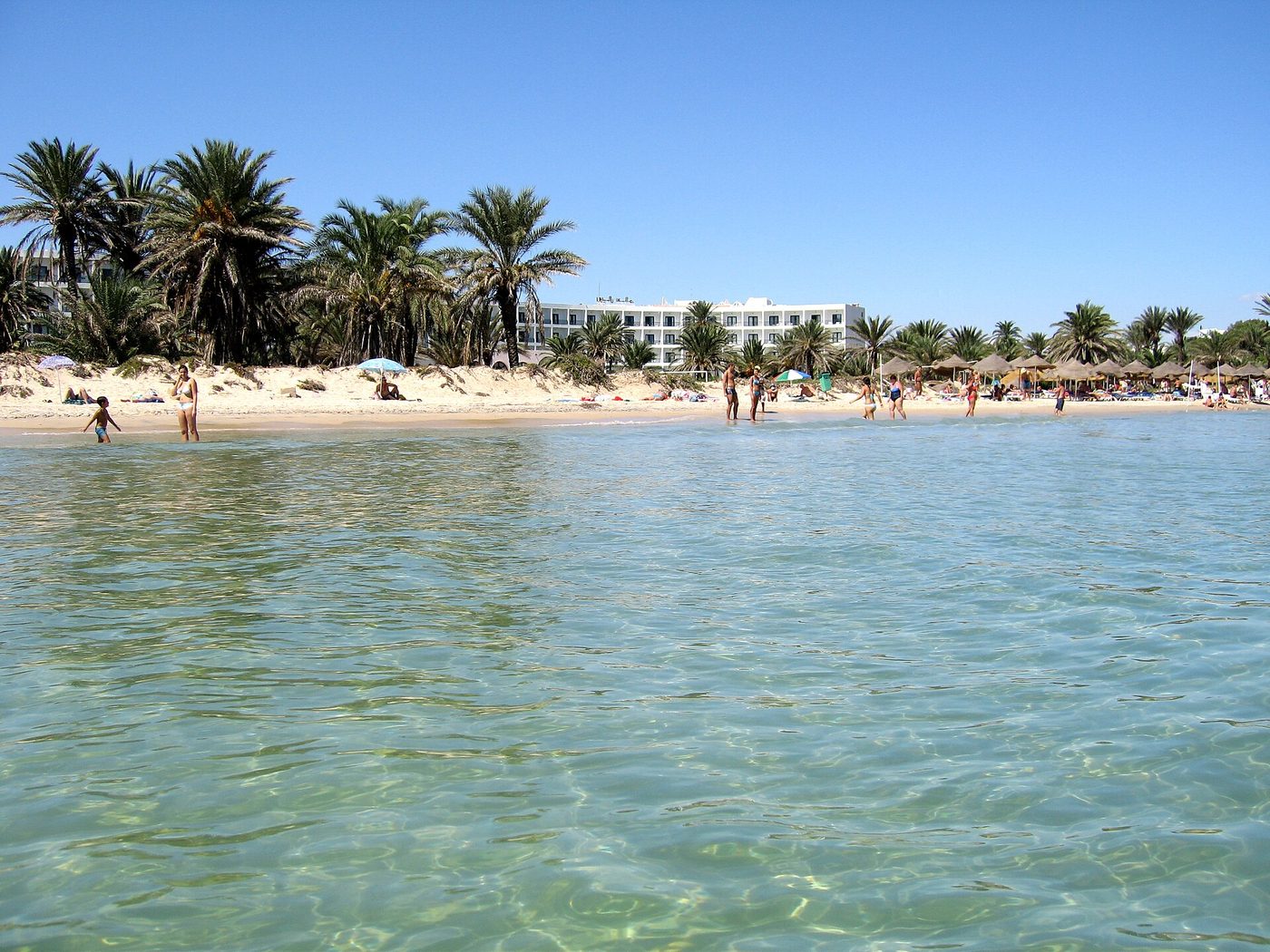 The busy summer beach and warm sea at Sousse, Tunisia in July