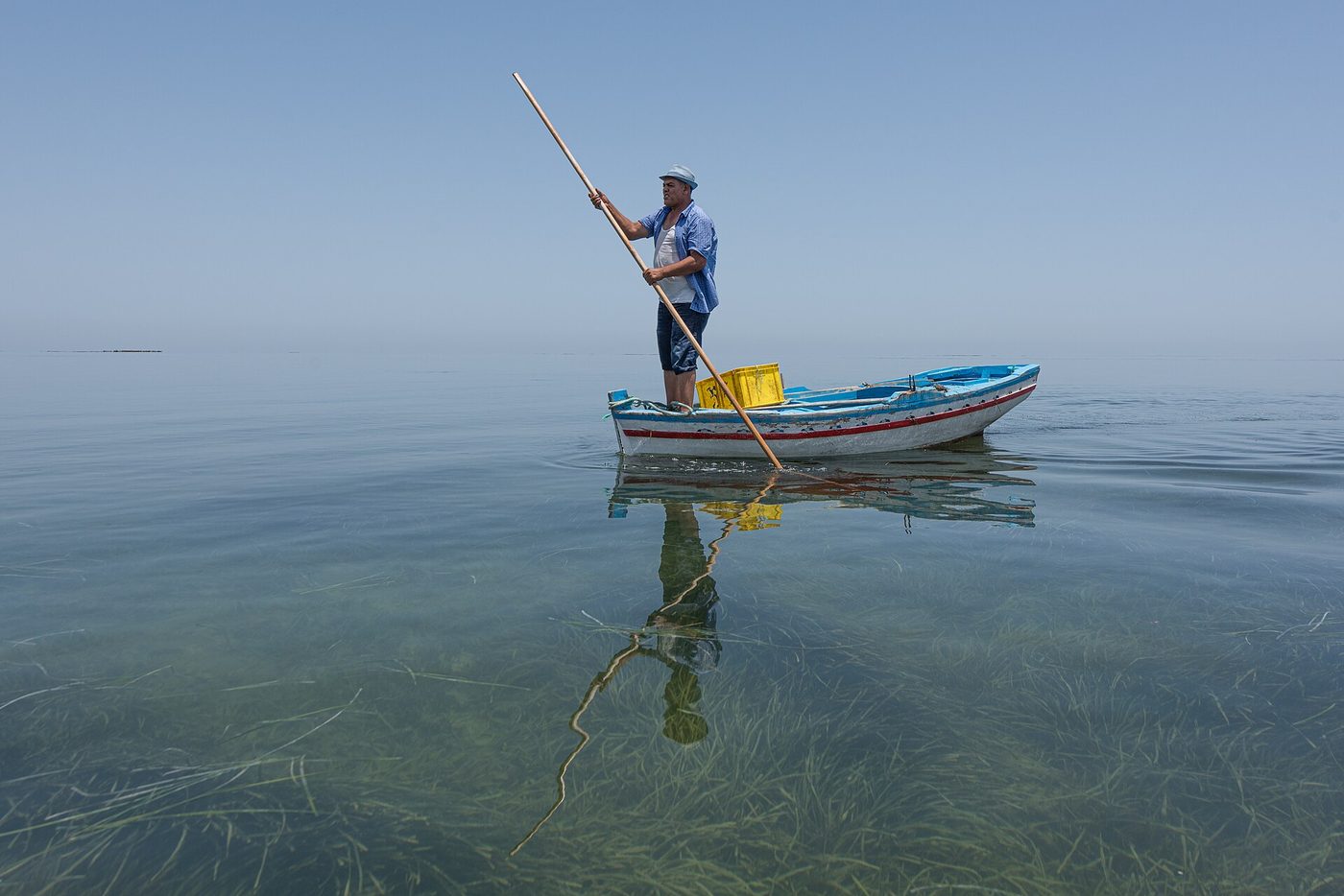 A traditional flat-bottomed fishing boat and palm-frond traps in the Kerkennah Islands, Tunisia