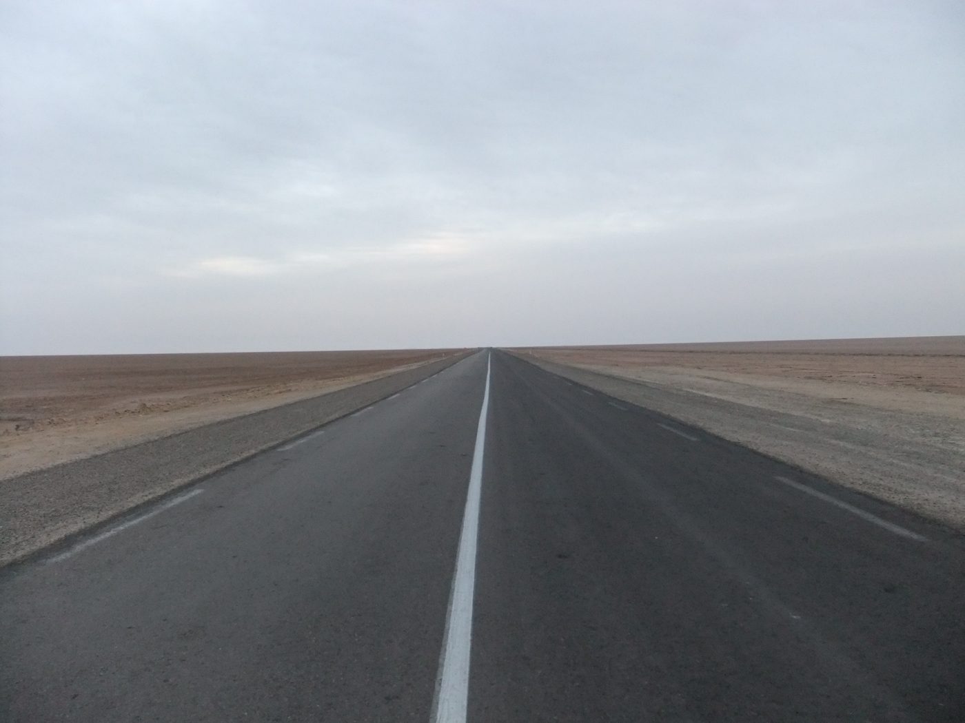 An empty desert road in southern Tunisia on a self-drive road trip