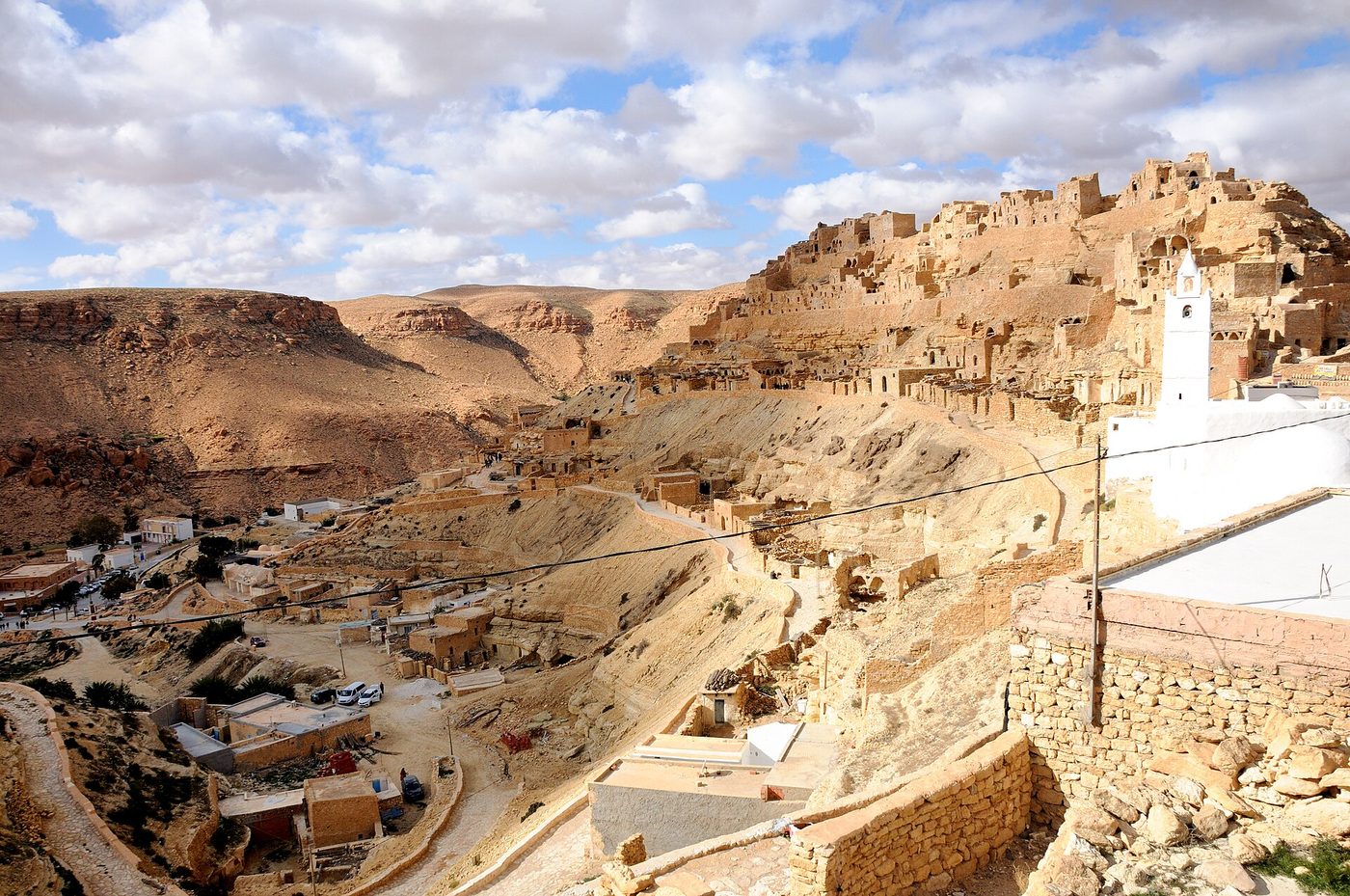 Panoramic view of the Berber hilltop village of Chenini near Tataouine, Tunisia, with cave dwellings on the ridge and the white mosque below