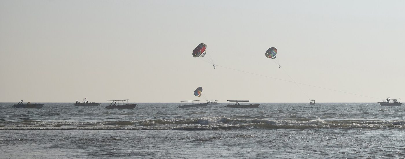 Parasails towed behind boats — the standard resort-beach setup